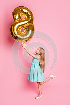 I am 8 years old! Vertical full-length side profile view portrait of cute lovely beautiful girl celebrating birthday, she is hold