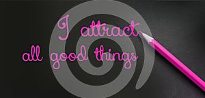 I attract all good things - positive affirmation words - handwriting on a black paper with a pink pencil. Law of attraction photo