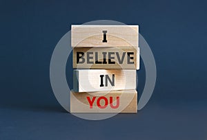 I believe in you symbol. Concept words `I believe in you` on wooden blocks on a beautiful grey background. Businessman hand.