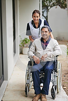 I can always count on the quality care here. Portrait of a senior man in a wheelchair being for for by a nurse at a