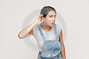 I can not hear you. Beautiful young adult lady. Studio shot, gray background