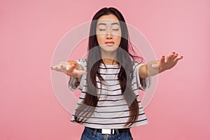 I can`t see. Portrait of brunette girl in striped t-shirt standing with closed eyes and outstretched hands