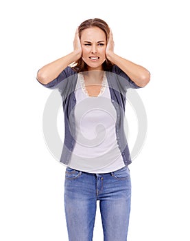 I cant take this noise. Casually dressed woman blocking her ears with a frown - isolated on white.