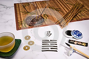 Close up of an I Ching arrangement with a handwritten Hexagram and different utensils photo