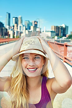 I choose urban living over everything. a smiling young woman walking around the city in the summertime.