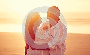 I could dance with you forever. an affectionate mature couple embracing on the beach at sunset.