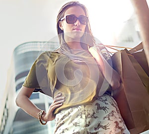 I could give up shopping... but Im not a quitter. A stylish young woman carrying shopping bags in the city.