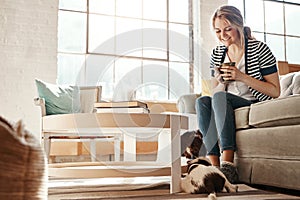 I couldnt ask for better company today. a young woman spending a relaxing day at home with her dog.