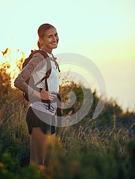 I couldnt be happier getting away from it all. Portrait of a young woman out on a hike through the mountains.