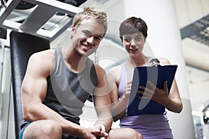 I couldnt have done it without her. Cropped portrait of a handsome young man and his personal trainer in the gym.