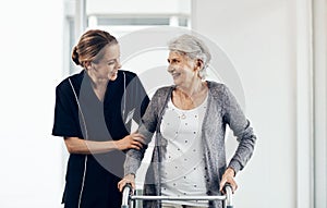 I couldnt have done it without your motivation. a female nurse assisting a senior woman using a walker.