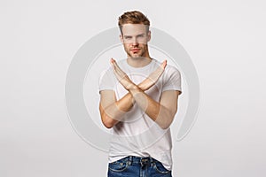 I disagree. Serious-looking blond guy with bristle making cross, stop gesture over chest and looking assertive camera