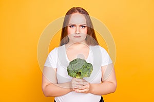 I dislike eating broccoli I prefer junk food! Portrait of unhappy upset sad frustrated woman dressed in white tshirt, she is