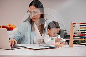 I do it all for you. Shot of a young mother working from home while holding her baby.