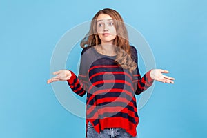 I don& x27;t know. Confused young beautiful woman wearing striped casual style sweater shrugging