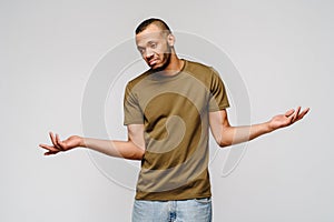 I don`t know gesture - Young afrcian american man over grey background being at a loss, showing helpless gesture with