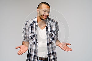 I don`t know gesture - Young afrcian american man over grey background being at a loss, showing helpless gesture with