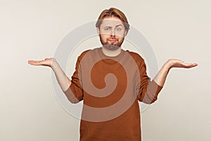 I don`t know! Portrait of clueless confused man with beard wearing sweatshirt shrugging shoulders
