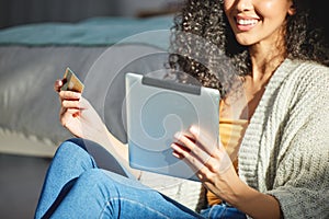 I dont even have to go to the bank. a young woman using her digital tablet to make online card payments.