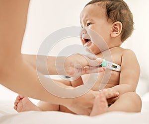 I dont like this, mom. a paediatrician taking a babys temperature with a thermometer.