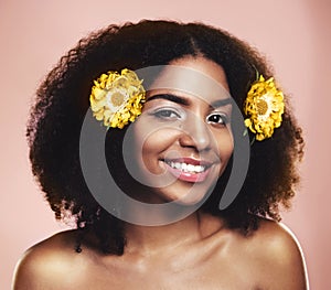 I feel a bit florally. Studio shot of a beautiful young woman posing with flowers in her hair.