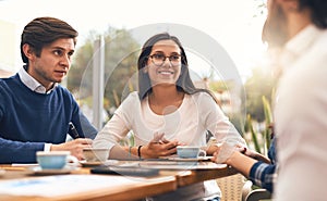 I feel that this is a solid idea. a group of creative businesspeople having a meeting around a table outside of a