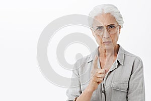 I forbid you. Portrait of strict and serious disappointed granny with white hair in glasses frowning with mad expression