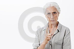 I forbid you. Portrait of strict and serious disappointed granny with white hair in glasses frowning with mad expression photo