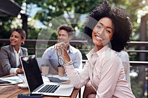 I form part of the best team. Cropped portrait of an attractive young businesswoman sitting with her colleagues during a