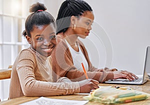 I get my work ethic from mom. a young mother using a laptop while her daughter does homework at home.