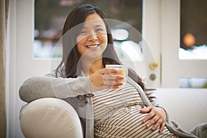 I get to indulge whatever cravings my hormones concoct. Portrait of an attractive young pregnant woman drinking an iced