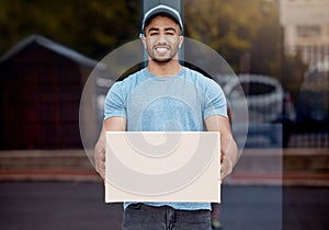 I got here as quick as I could. Portrait of a young delivery man holding a box.