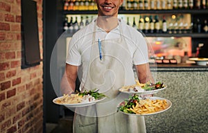 I got what you ordered right here sir. Shot of an unrecognizable waiter holding three plates of food that hes going to