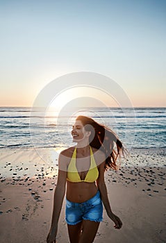 I had my dos of vitamin sea. a beautiful young woman enjoying herself at the beach at sunset.