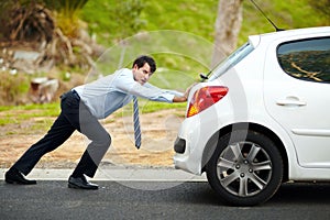 I hate having car trouble. Portrait of an unhappy man pushing his car.