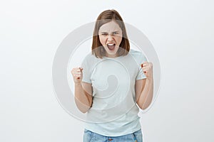 I hate rules. Portrait of outraged and angry young woman with short brown hair looking from under forehead