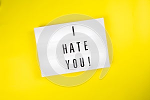 I Hate You! message on lightbox on yellow background isolated Top view, flat lay