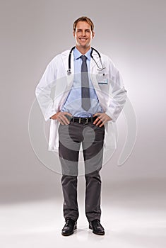 I have confidence in his care. Full length shot of a young doctor standing with his hands on his hips.