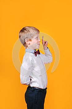 I have idea. Child boy with finger up Little funny genius student thinking on yellow background.