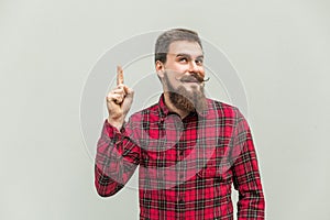 I have idea! Handsome businessman with beard and handlebar mustache looking at camera with finger up