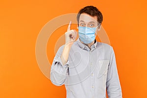 I have idea. Portrait of excited young worker man with surgical medical mask standing with surprised face and has a idea