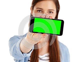I have a new app to show you. A young woman holding a mobile phone with green screen copyspace.