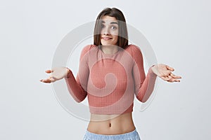 I have no idea. Portrait of young attractive caucasian student girl with dark long hair in pink shirt and blue