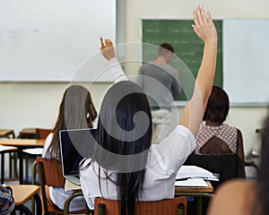 I have a question...A female student raising her hand to ask a question during class.