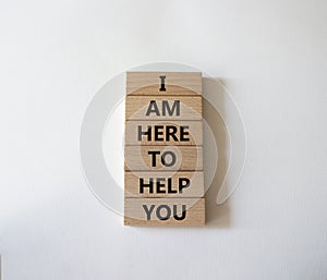 I am here to help symbol. Concept words I am here to help on wooden blocks. Beautiful white background. Businessman hand. Business