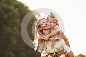 I hold you, don`t worry. Mother and daughter enjoying weekend together by walking outdoors in the field. Beautiful nature