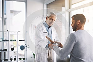 I honestly cant feel a thing. a senior doctor giving his male patient a thorough checkup during his consultation.