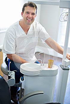 I hope youve been brushing. Portrait of a male dentist sitting by the dental equipment in his office.