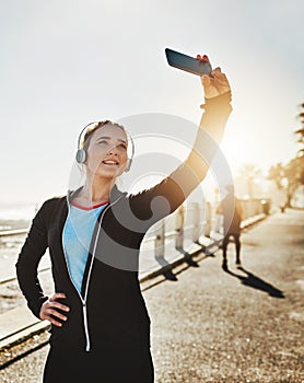 I inspire others to live healthy too. Cropped shot of a sporty young woman taking a selfie while out on the promenade.