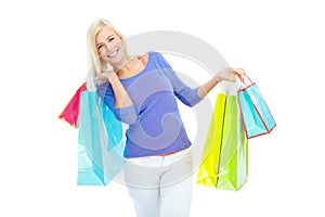 I just bought some really amazing clothes. An excited young woman holding shopping bags while isolated on a white